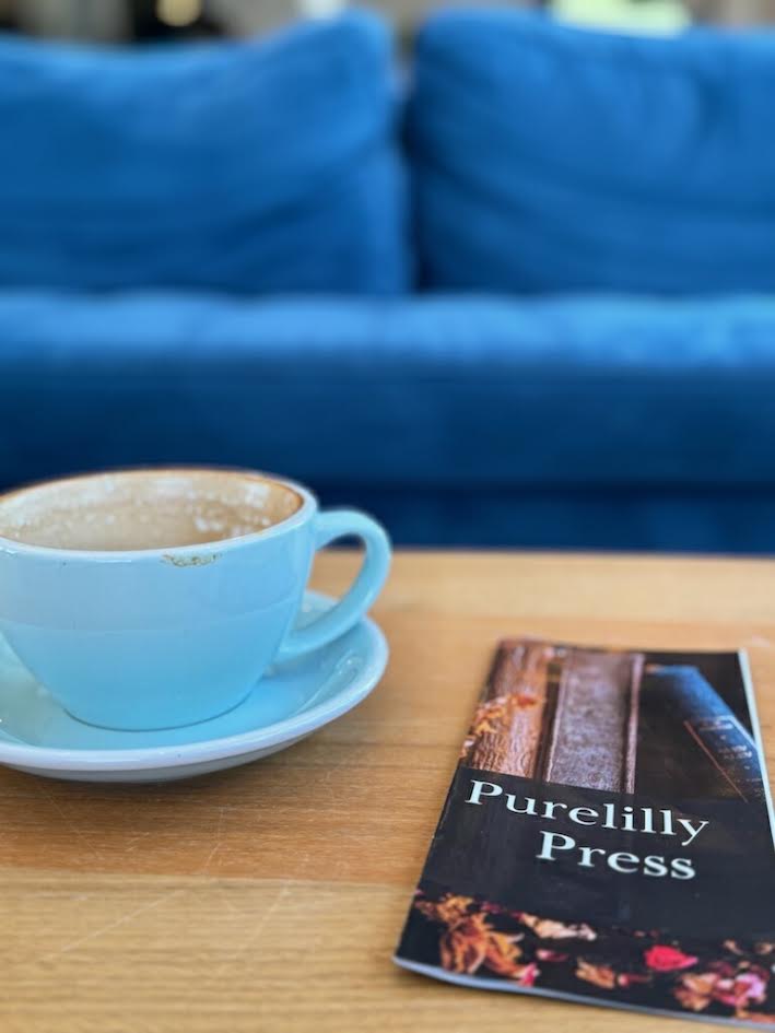 Purelilly Press brochure beside a coffee cup